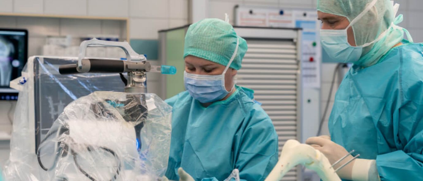 Ärztin und Arzt bei robotergestützter Knie-OP