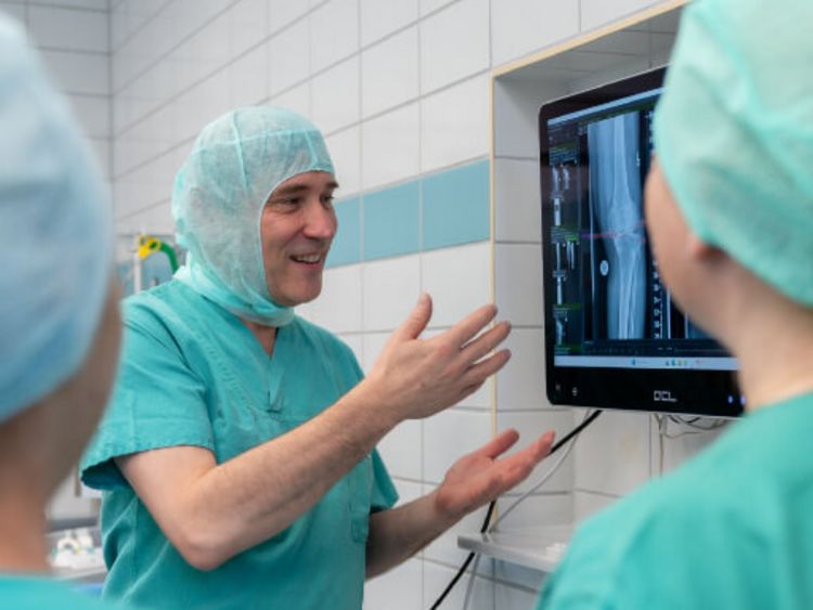 Ärztin und Arzt bei robotergestützter Knie-OP