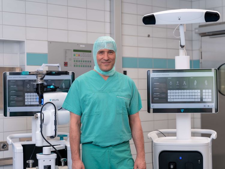 Arzt präsentiert Roboter für robotergestützte Knie-OP