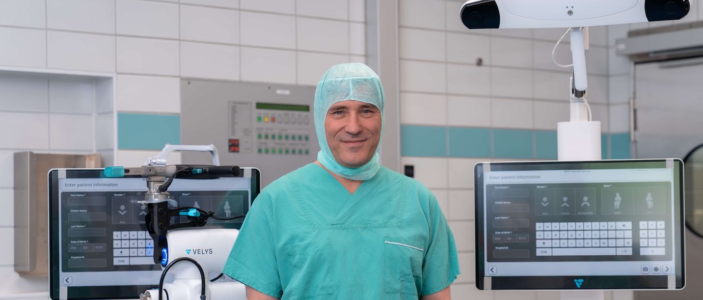 Arzt präsentiert Roboter für robotergestützte Knie-OP