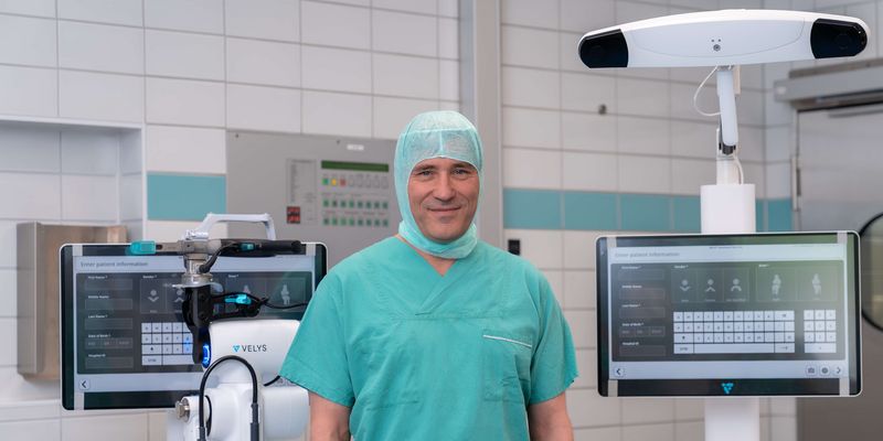 Arzt präsentiert Roboter für robotergestützte Knie-OP