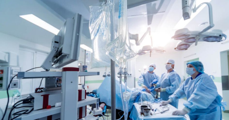 Ein Ärzteteam mit Mundschutz operiert einen orthopädischen Patienten