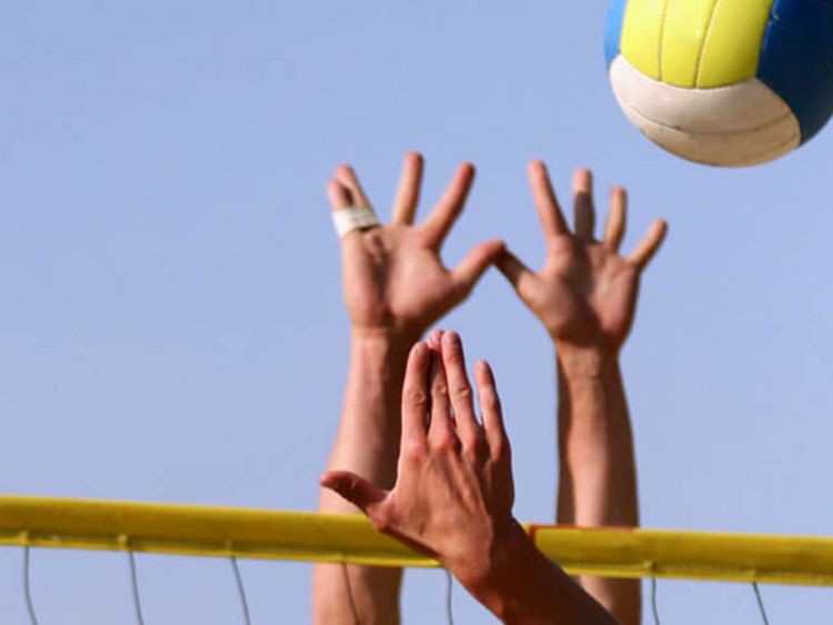 Hände und Volleyball beim Beachvolleyball