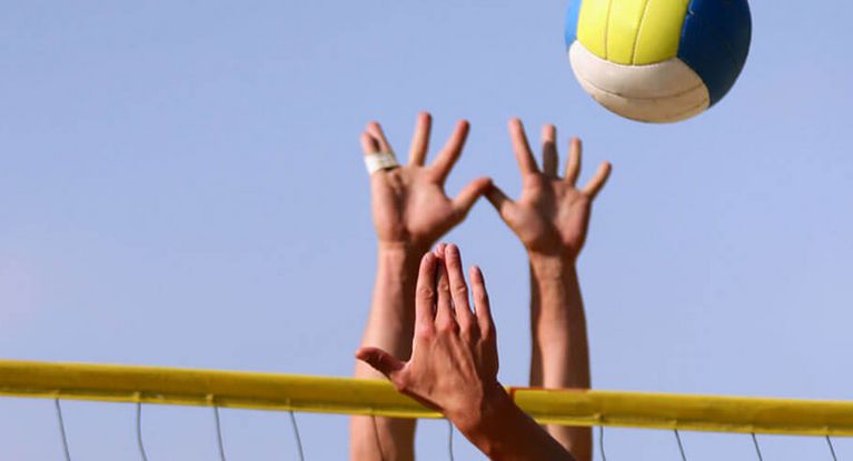 Hände und Volleyball beim Beachvolleyball