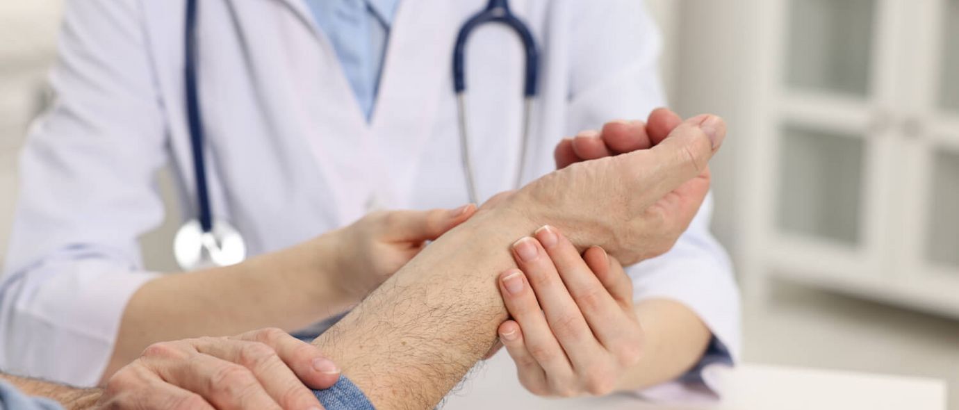 Arzt untersucht den Arm eines Patienten